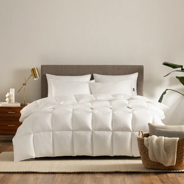 Serta Down Illusion Down Alternative Comforter - Extra Warmth draped on top of a mattress with 4 pillows on top of it in a bedroom setting.