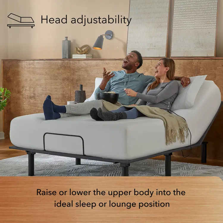 Man and Woman sitting in a Baselogic Bronze Adjustable Base with a white mattress on top of it.